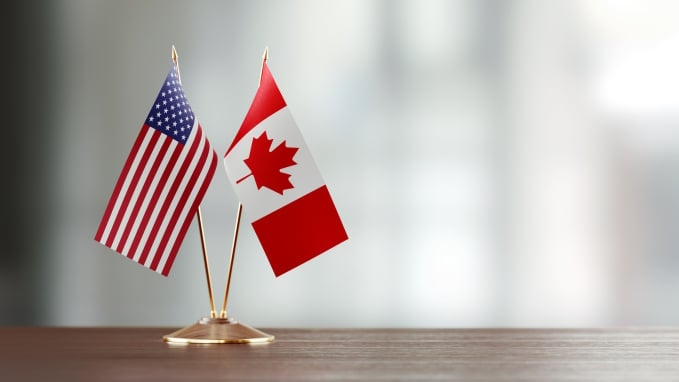 Canada and US flags displayed on a desk